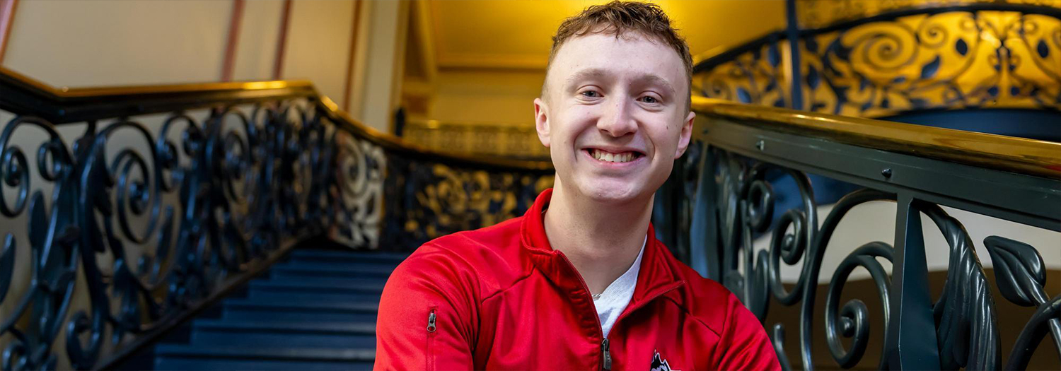 Zander Ward smiling while seated on a staircase