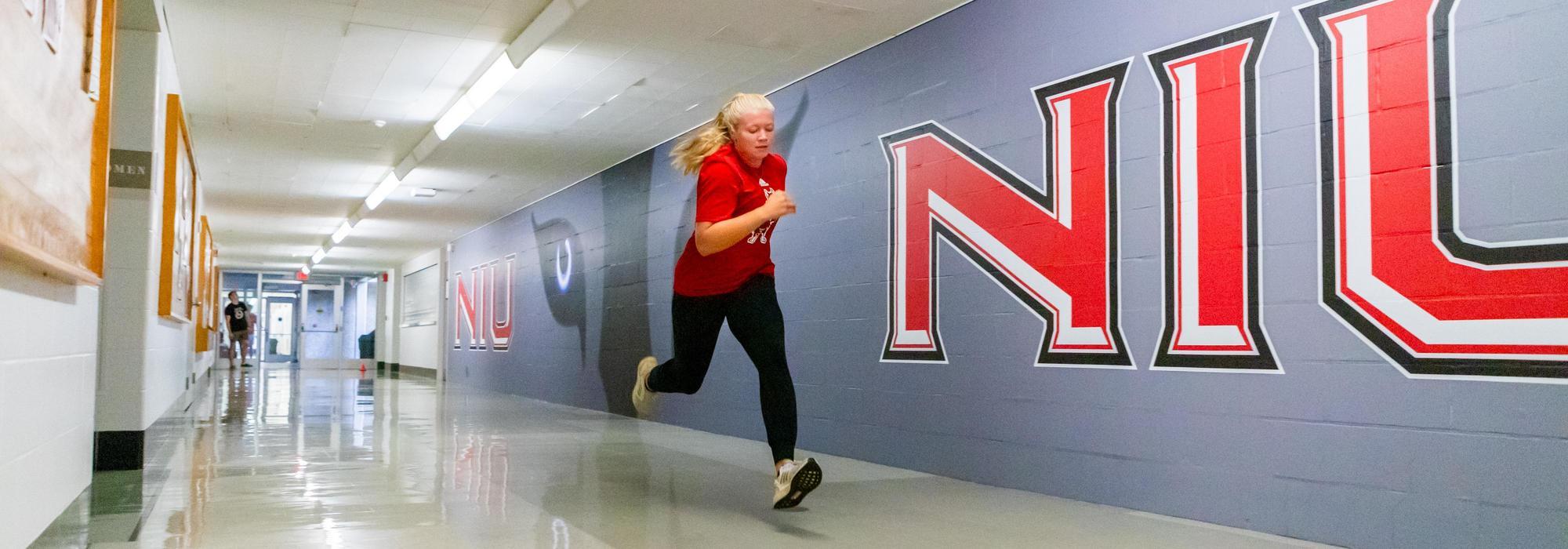 Student running in an NIU hallway.